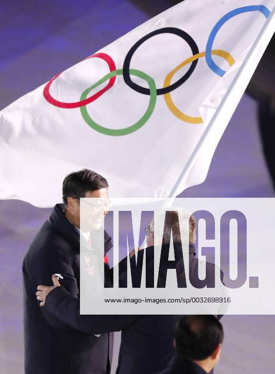 Pyeongchang Olympics International Olympic Committee President Thomas Bach (R) hands over the Olympic flag to Beijing Mayor Chen Jining during the closing ceremony of the Winter Olympics at the Pyeongchang Olympic Stadium in South Korea on Feb. 25, 2018.