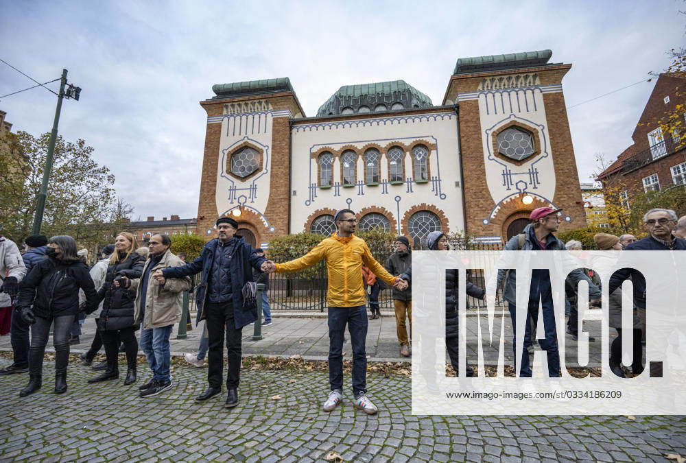 MALMÖ, SWEDEN 20231111 People hand in hand with the initiator Showan Shattak yellow jacket form a circle around the Synagogue in Malmö during a demonstration in support of Malmös Jews on Saturday The demonstration was a response to last weekends burning of the Israeli flag next to the Synagogue in Malmö and a new application for a similar d