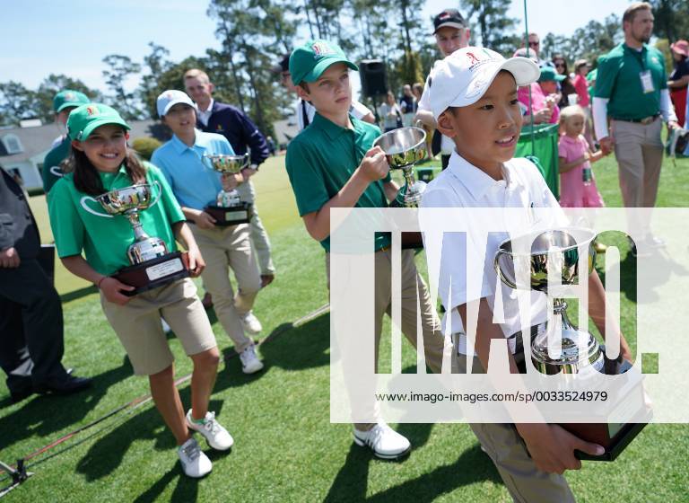 Winners in the Drive Chip & Putt National Finals carry their trophies at Augusta National Golf Club during Masters week on April 1, 2018 in Augusta, Georgia. AUG20180401323 KEVINxDIETSCH
