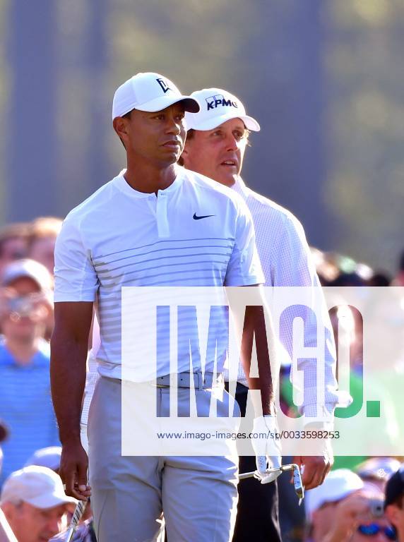 Tiger Woods (L) and Phil Mickelson watch together on the 12th tee during a practice round prior to the Masters golf tournament at the Augusta National Golf Club, on April 3, 2018 in Augusta, Georgia. AUG20180403317 KEVINxDIETSCH