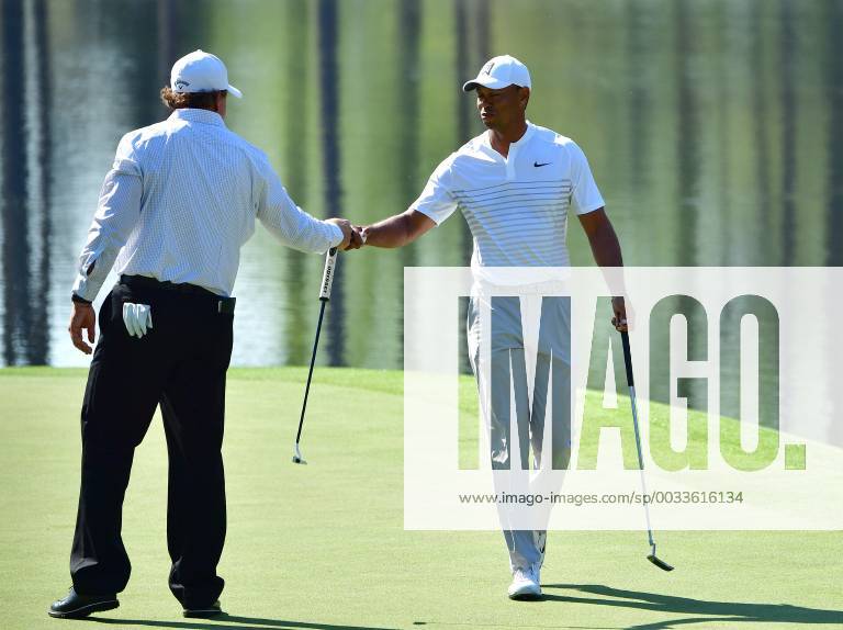 Phil Mickelson fist bumps Tiger Woods after Woods sunk a putt on the 16th green during a practice round prior to the Masters golf tournament at the Augusta National Golf Club, on April 3, 2018 in Augusta, Georgia. AUG20180403321 KEVINxDIETSCH