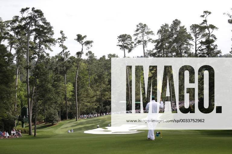 A caddie watches play on the 10th green in the 2nd round of the 2018 Masters Tournament at the Augusta National Golf Club in Augusta, Georgia, on April 6, 2018. AUG20180406152 JOHNxANGELILLO
