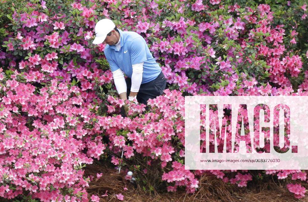Rory McIlroy of Northern Ireland hits his golf ball out of a pack of azalea plants behind the 13th green in the 3rd round of the 2018 Masters Tournament at the Augusta National Golf Club in Augusta, Georgia, on April 7, 2018. AUG20180407122 JOHNxANGELILLO