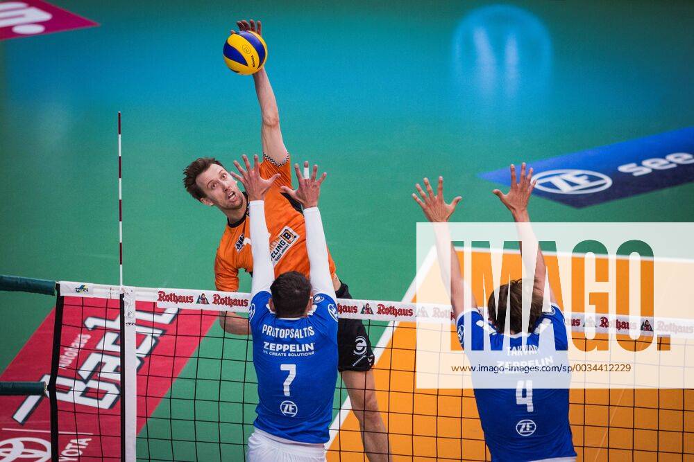 Friedrichshafen Germany 26 04 2018 Paul Carroll BR Volleys 12 against the block from Athanasios Protopsaltis Friedrichshafen 7 and Andreas Takvam Friedrichshafen 4 at the Playoff Final Game 1 of the Volleyball Bundesliga between VfB Friedrichshafen and the Berlin Recycling Volleys
