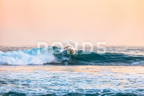 A shot of a male surfing on the sea during daytime ocean, tropical, surf, body of water, sea, day, surfboard, water, surfing, beach, wave, board, sport, coast, surfer, waves, sky, nature, summer, vacation, holiday, travel, blue, extreme, people, hawaii, sand, fun, landscape, palm, active, sun, retro, shore, vintage, young, sunlight, outdoor, view, tree, high, horizontal, lifestyle, seascape, background, tahiti, man, nobody, paradise, wet