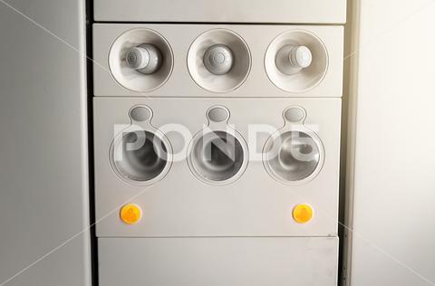Adjustable lights and air conditioners overhead seat controls of a commercial aircraft. Closed air conditioners nozzles airplane, knob, passenger cabin, control panel, air vehicle, control, technology, flying, push button, travel, airplane seat, seat, transportation, sign, symbol, design, safety, equipment, commercial airplane, passenger, airplane interior, airline, ceiling, aeroplane, console, ventilation, conditioning, conditioner, board, fly, aircraft, panel, button, cabin, flight, overhead, plane, nozzles, closed, round, adjustable, icon, light, transport, seating, nobody, security, plastic