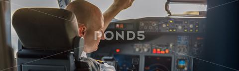 Focused professional pilot sitting in an airplane cabin, ready for takeoff. Aircraft, aircrew, occupation concept adult, adults, air, aircraft, airline, airliner, airplane, airport, attractive, auto pilot, aviator, background, boarding, business, cabin, cockpit, commercial, crew, flight, fly, focused, guy, horizontal, job, journey, landing, man, occupation, people, person, pilot, plane, preparing, professional, ready, real, service, simulator, sitting, takeoff, tourism, transport, transportation, travel, trip, uniform, work
