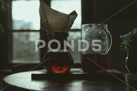 A closeup shot of homemade dandelion syrup on glass containers on a wooden table homemade, dandelion syrup, containers, transferring, vase, flower, table, surface, wooden, closeup, nature, plant, caramel, glass, food, sweet, container, drop, dessert, liquid, mixed, healthy, sweetness, sweetener, wooden surface, selective, focus, blurred, blurry