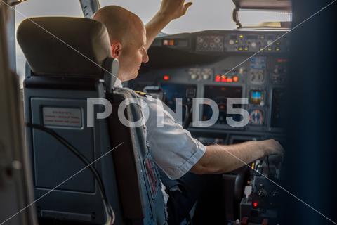 Focused professional pilot sitting in an airplane cabin, ready for takeoff. Aircraft, aircrew, occupation concept background, business, person, man, pilot, plane, aircraft, aviator, cabin, commercial, people, job, crew, flight, airliner, airplane, fly, professional, ready, transport, transportation, travel, uniform, work, service, sitting, attractive, focused, preparing, guy, journey, occupation, tourism, trip, adults, auto pilot, airport, adult, simulator, cockpit, real, air, takeoff, airline, landing, boarding, horizontal