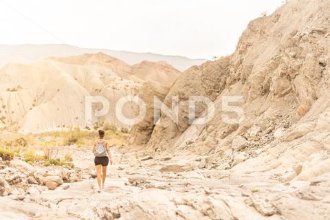 Back view of anonymous female tourist with backpack exploring sandy mountainous terrain in Tabernas desert woman, traveler, tourist, desert, adventure, wanderlust, hike, vacation, trekking, nature, mountain, archaeologist, explorer, arid, dry, valley, lady, walk, journey, trip, tabernas, backpack, terrain, explore, spain, tourism, landscape, travel, scenic, almeria, waterless, discovery, ridge, activity, formation, sky, range, cloudless, daytime, sunlight, alone, outdoors, copy space, anonymous, unrecognizable, back view