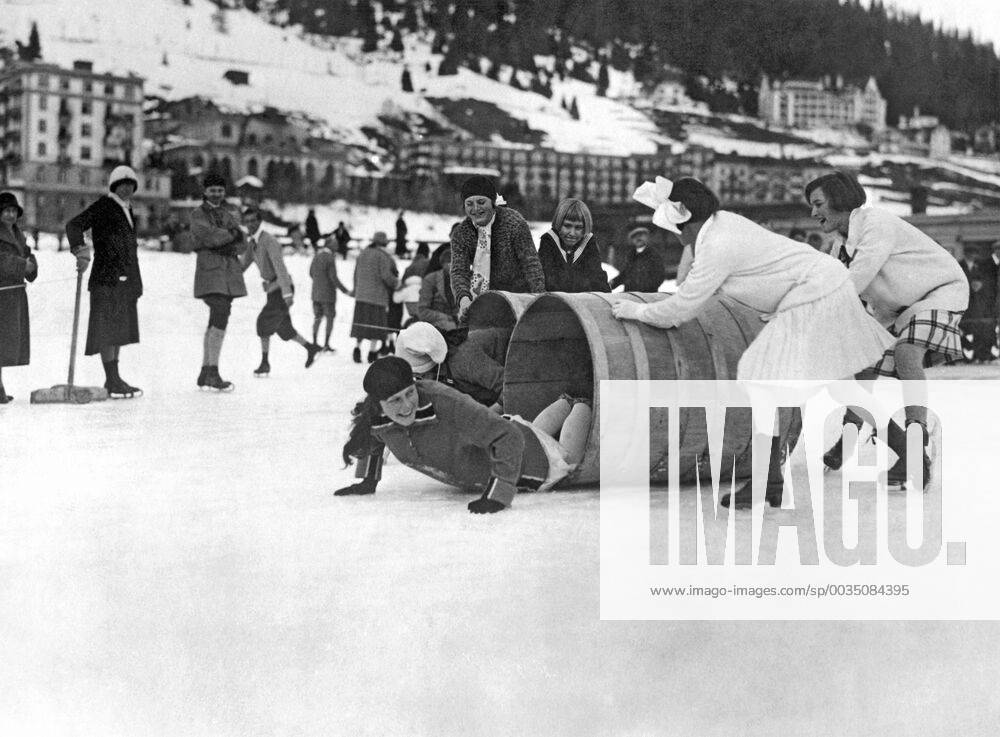 Davos, Switzerland: c. 1928. Young girls crawling through barrels as part of an ice skating obstacle race in Switzerland. xUnderwoodxArchives 3-Sport-IS-P_3 990_16_3-Sport-IS-P_3HR