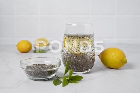 A close-up shot of a glass of water with chia seeds and lemon on a white background chia, healthy, mint, seed, lemon, fresh, glass, background, drink, organic, closeup, raw, diet, isolated, ingredient, refreshment, water, eating, nature, table, green, vegetarian, studio, object, vitamin, ripe, soda