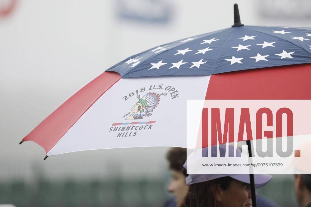 Fans stand under an umbrella on the Wednesday before the 118th U.S. Open Championship at Shinnecock Hills Golf Club in Southampton, New York on June 13, 2018. NYP20180613301 JOHNxANGELILLO