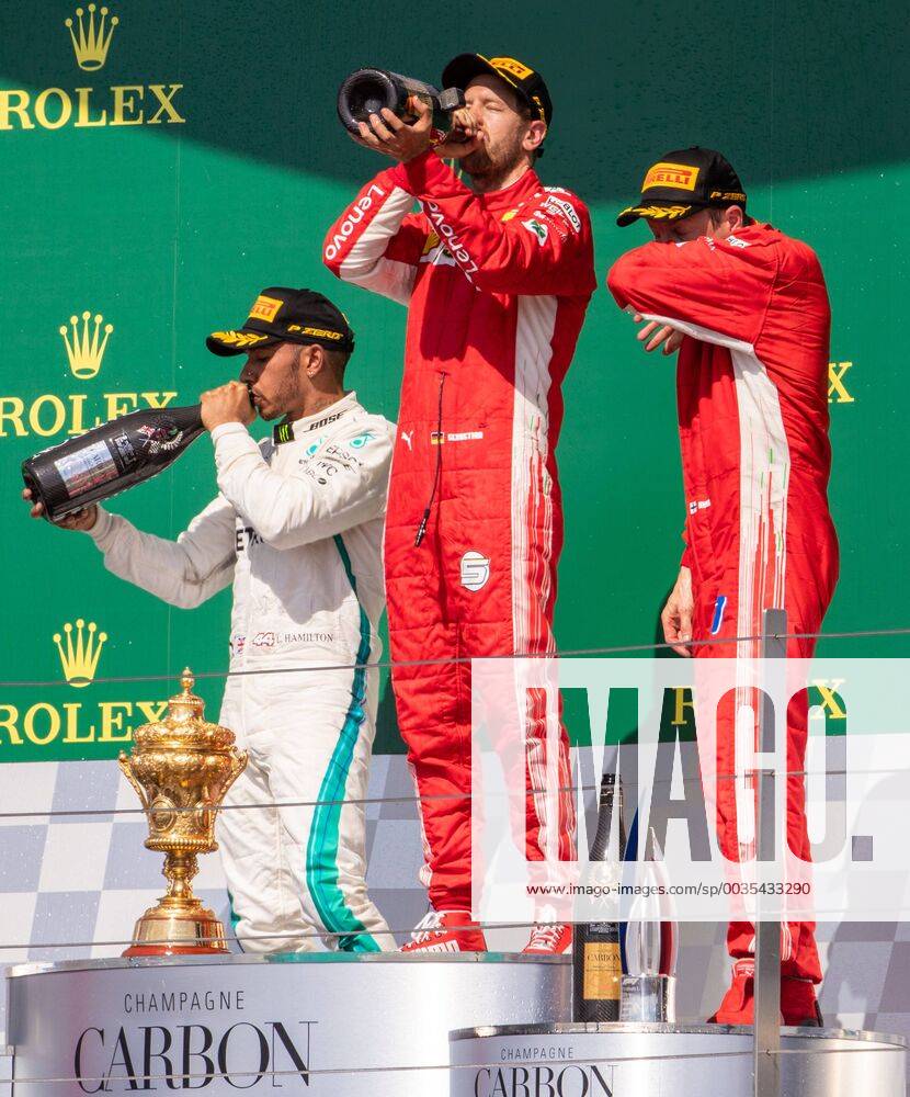 8th July 2018, Silverstone Circuit, Silverstone, England; British Formula One Grand Prix, Race Day; Scuderia Ferrari driver Sebastian Vettel and Mercedes driver Lewis Hamilton drink from the Champagne bottle ActionPlus12045549 TimxWilliams