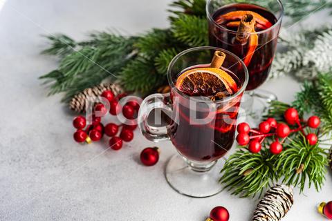 Mulled wine with spices with holiday decoration on white concrete background anise star, berry, beverage, christmas, cinnamon, spicy, drink, festive, fir tree, holiday, mulled, orange, pine, traditional, red, slice, spice, sticks, wine, winter, ingredient, cardamom, xmas, nutmeg, aromatic, moody, sweet, aroma, cocktail, wineglass, seasonal, rustic, table, clove, cup, warm, homemade, glass, alcohol, punch, hot, food, fruit, celebration, decoration, season, gourmet, mug, party