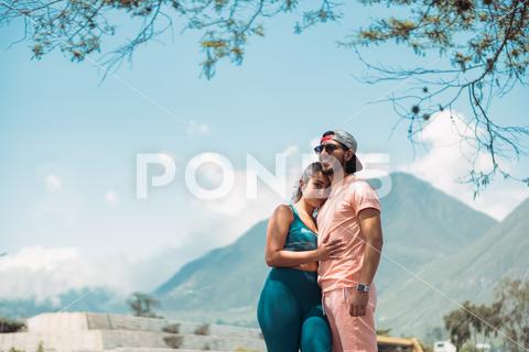 Young female in sportswear putting head on boyfriends shoulder while embracing near green tree against mountains on sunny day {{couple,hug,nature,mountain,relationship,embrace,love,bonding,care,fondness,happy,boyfriend,girlfriend,park,tree,sportswear,fit,young,romantic,close,daytime,idyllic,tender,harmony,partner,rest,cuddle,wellness,sunshine,support,weekend,countryside,touch,sport,healthy lifestyle,peaceful,amour,tranquil,amorous,soulmate,spend time,outdoors,outside}}