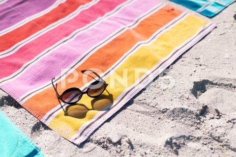 High angle view of sunglasses and colorful towel on sandy beach during sunny day. Copy space, unaltered, protection, vacation, fashion, picnic and summer concept. No People, High Angle, Angle View, Sunglass, Colorful, Towel, Sandy Beach, Sunny Day, Copy Space, Unaltered, Protection, Vacation, Fashion, Picnic, Summer Concept, Holiday, Beautiful, Color, Summer, Beauty, Travel, Style, Beach, Sea, Tourism, Blue, Ocean, Water, Background, Pattern, Bright, Art, Safety, Design, Texture, High, Angle, View, Sandy, Sunny, Day, Copy, Space, Concept