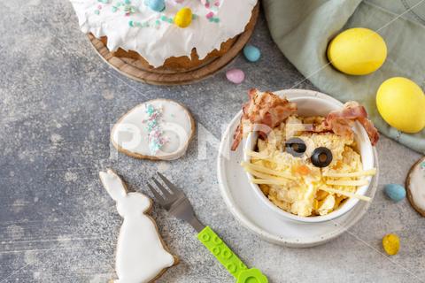 Scrambled eggs easter bunny on a stone background. Easter breakfast idea. Copy space. easter, bunny, holiday, bacon, scrambled eggs, breakfast, food, funny, healthy, rabbit, meal, art, background, egg, cooking, copy space, idea, plate, concept, fun, celebration, recipe, festive, tasty, decoration, nutrition, homemade, creative, cooked, eggs, eating, kids, gourmet, dish, top view, cheeses, black olives, child, snack, kid, scrambled, children, morning, lunch, easter bunny, omelette, springtime, protein, easter meal