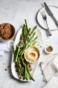 Top view of yummy hummus with asparagus served on white plate near bowl of crispy seed crackers on marble table in kitchen asparagus, hummus, cracker, delicious, culinary, meal, food, seed, cuisine, yummy, nutrition, middle eastern, crispy, kitchen, vegetarian, breakfast, palatable, appetizing, tasty, lunch, plate, cutlery, healthy, ingredient, gastronomy, dish, bowl, grain, serve, snack, gourmet, rustic, nutrient, cereal, food photography, crunch, tradition, product, vitamin, daytime, healthy food, delectable, marble, portion, indoors, from above, top view