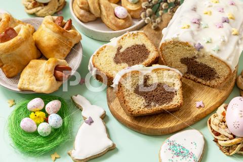 Festive dinner, Easter brunch. Happy Easter holiday food baking puff pastry and cupcake with Easter Bunny on pastel green background. bunny, spring, holiday, food, rabbit, sweet, homemade, menu, puff pastry, dessert, cake, background, celebration, symbol, festive, springtime, party, easter bunny, eggs, snack, creative, pastry, season, greeting, decor, seasonal, happy, happy easter, bakery, card, beautiful, table, event, recipe, easter eggs, easter rabbit, colorful eggs, above, bake, bakers, buns, christian, cinnamon, cooked, cookie, cooking, copy, culinary, flat lay