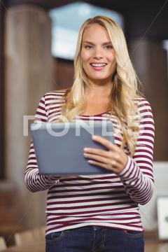 Portrait of young businesswoman using digital tablet in office 20s, Young Adult, Woman, Female, Caucasian, Tablet Computer, Digital Tablet, Tablet Pc, Tablet, Holding, Using, Fair Hair, Blonde, Light Hair, Creative, Business, Casual, Cool, Studio, Office, Job, Profession, Professional, Career, Occupation, Hip, Style, Standing, Smiling, Cheerful, Happy, Pretty, Long Hair, Attractive, Striped, Businesswoman, Indoors, Looking At Camera