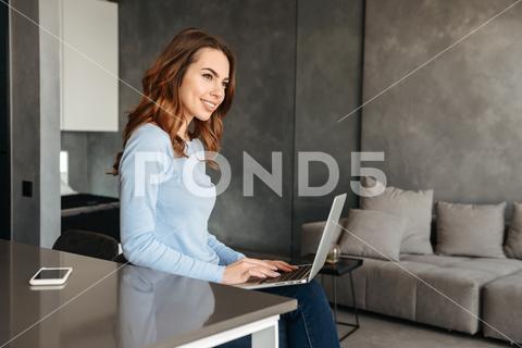 Portrait of a pretty young woman using laptop computer while sitting at the kitchen table at home beautiful, woman, kitchen, chair, female, home, sitting, adult, young, house, laptop, indoor, interior, computer, girl, holding, technology, apartment, happy, work, modern, table, business, caucasian, domestic, communication, attractive, cheerful, internet, resting, mobile, lifestyle, casual, connection, businesswoman, joyful, browsing, using, relaxation, charming, cute, leisure, people, workplace, smile