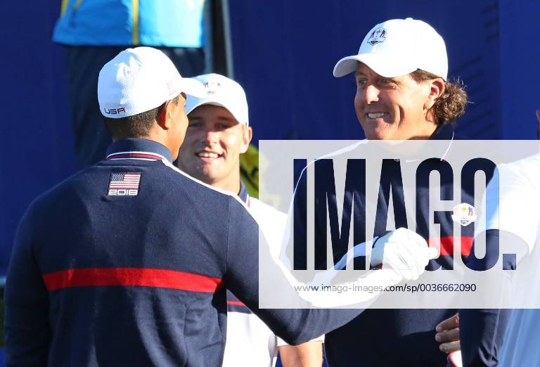 Tiger Woods (L) greets his U.S. teammates Bryson DeChambeau (C) and Phil Mickelson before a practice session at Le Golf National in Guyancourt near Paris on September 25, 2018. PAR20180925009 DAVIDxSILPA