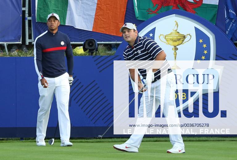 Patrick Reed, flanked byTiger Woods, hits his opening shot on the first tee at the start of the Ryder Cup at Le Golf National in Guyancourt near Paris on September 28, 2018. Team USA will compete against Team Europe in the three-day tournament. PAR20180928086 DAVIDxSILPA