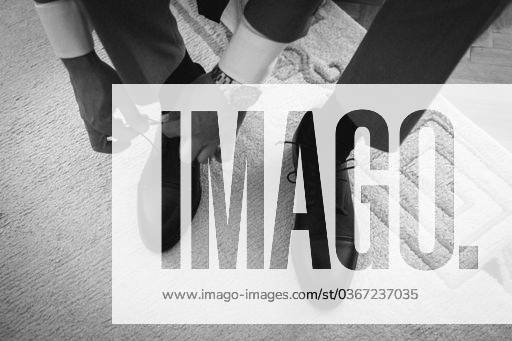 A man in a formal suit is in the process of tying his shoes, getting ready for a wedding ceremony 21862495 RECORD DATE NOT STATED