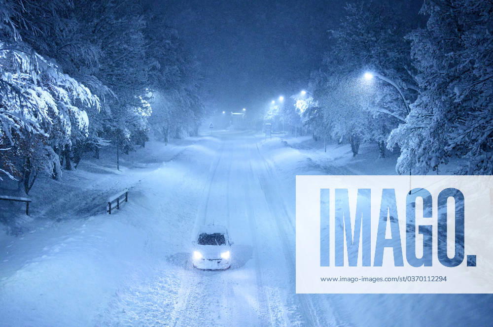 Cars covered by snow and snow plows try to combat the heavy onset of winter and snowfall at midnight in Marktoberdorf, Bavaria, Allgäu, Germany