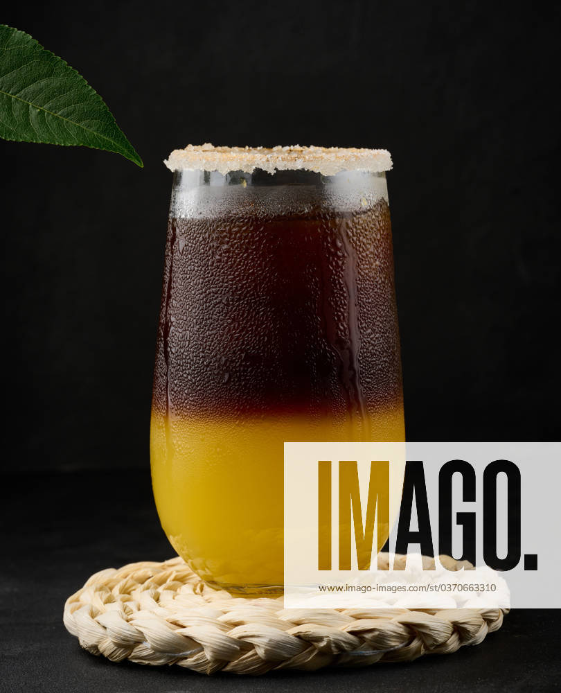 Iced coffee with orange juice in a transparent glass, refreshing bumble coffee on the table, black background Iced coffee with orange juice in a transparent glass, refreshing bumble coffee on the table, black background