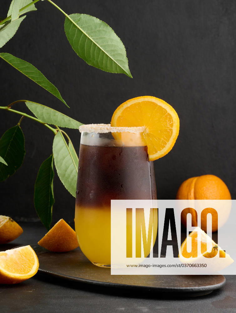 Iced coffee with orange juice in a transparent glass, refreshing bumble coffee on the table Iced coffee with orange juice in a transparent glass, refreshing bumble coffee on the table