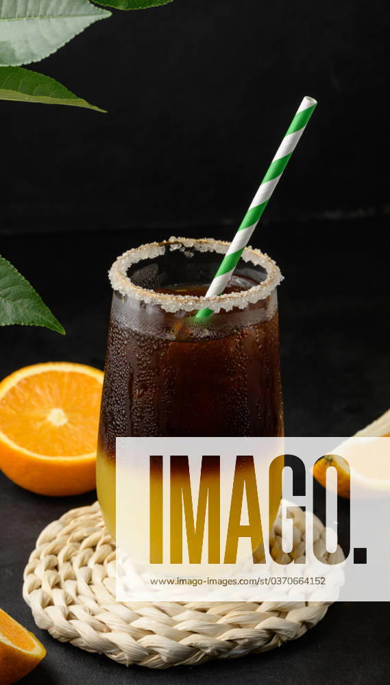 Iced coffee with orange juice in a transparent glass, refreshing bumble coffee on the table, black background Iced coffee with orange juice in a transparent glass, refreshing bumble coffee on the table, black background
