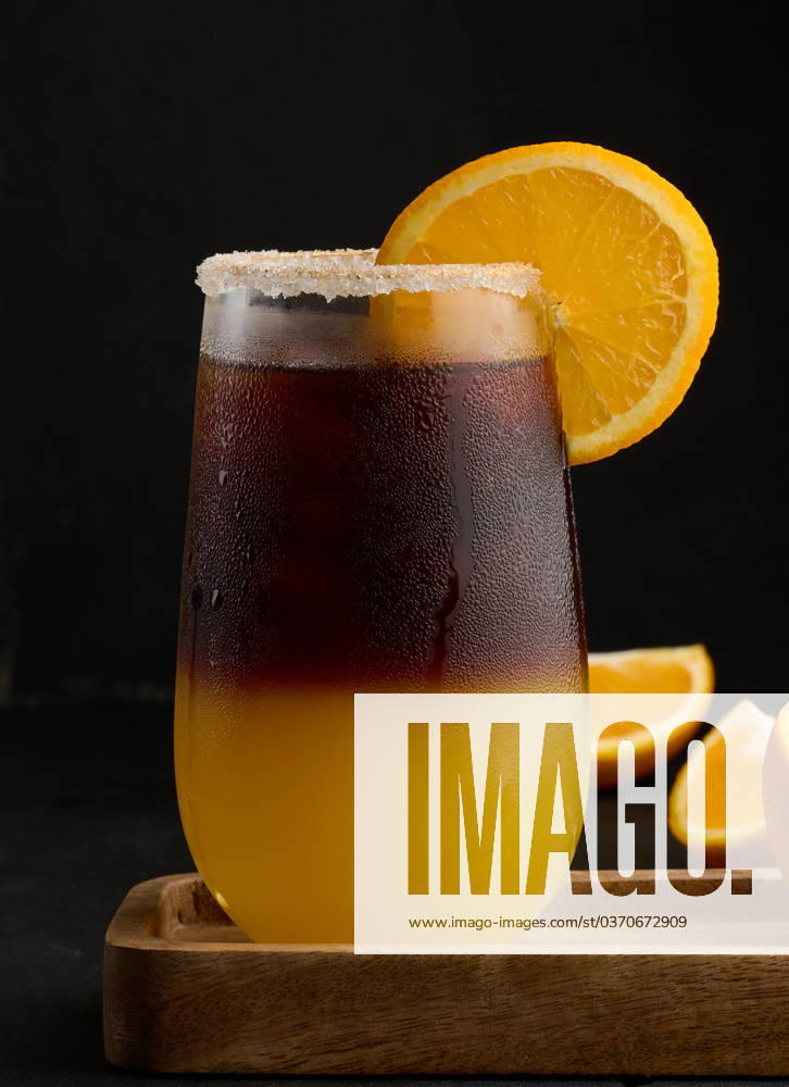 Iced coffee with orange juice in a transparent glass, refreshing bumble coffee on the table, black background Iced coffee with orange juice in a transparent glass, refreshing bumble coffee on the table, black background