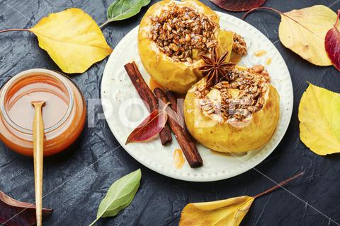 Baked apples stuffed with granola and nuts.Baking concept apple baked stuffed nut dessert autumn oatmeal filled food fruit dessert fruit baked apple sweet cinnamon plate delicious fall homemade sugar walnut tasty bake stuffed apple sweetness caramel season dish syrup sauce eat prepared cinnamon stick table caramel syrup scoop fallen leaves seasonal tempting granola appetizing stuffed apples