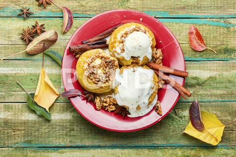 Baked apples stuffed with granola and nuts.Baking concept apple baked stuffed stuffed apples nut dessert autumn oatmeal filled food ice cream fruit baked apple sweet cinnamon plate delicious fall homemade sugar walnut tasty ice cream bake caramel season dish syrup sauce eat prepared cinnamon stick scoop fallen leaves seasonal tempting granola appetizing rustic wooden background wooden table