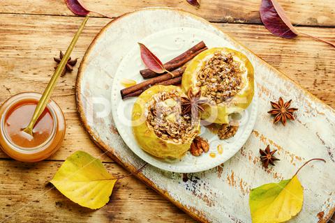Baked apples stuffed with granola and nuts.Baking concept apple baked stuffed fruit dessert caramel syrup stuffed apple sweetness stuffed apples nut dessert autumn oatmeal filled food fruit baked apple sweet cinnamon plate delicious fall sugar walnut tasty bake caramel season dish syrup sauce eat prepared cinnamon stick scoop fallen leaves seasonal food kitchen board tempting granola appetizing rustic wooden background wooden table