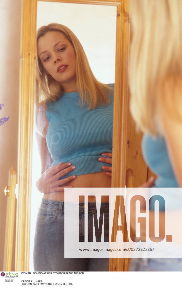 WOMAN LOOKING AT HER STOMACH IN THE MIRROR CREDIT ALL USES WOMAN LOOKING AT HER STOMACH IN THE MIRROR CREDIT ALL USES, Credit:Ken Bank Avalon
