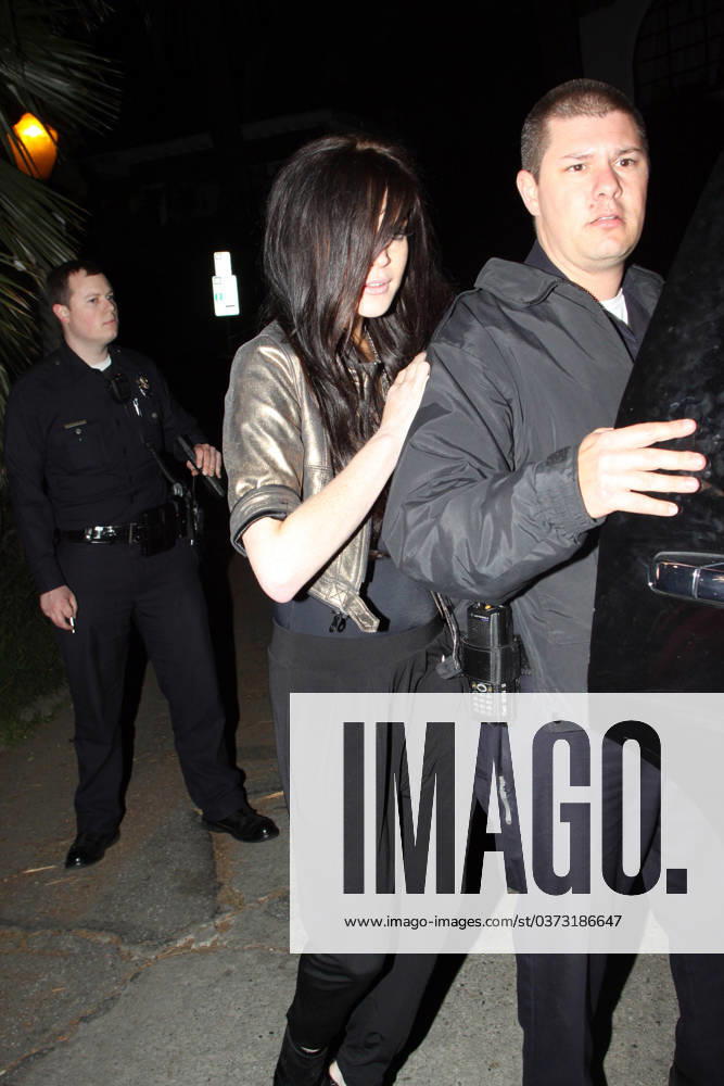 Lindsay Lohan gets a police escort to her vehicle as she leaves a house party at approx 05.30am 38894, WEST HOLLYWOOD, CALIFORNIA - Tuesday March 23 2010. Lindsay Lohan gets a police escort to her vehicle as she leaves a house party at approx 05.30am. The young actress managed to stay upright as she teetered out of the house on a pair of killer heels. She hadn t been so fortunate when she arrived, taking a tumble into an ornamental cactus bush!! (See PCN set 38889PCN_Lindsay). , Credit:David Tonnessen, PacificCoastNews.com Avalon USA, Los Angeles