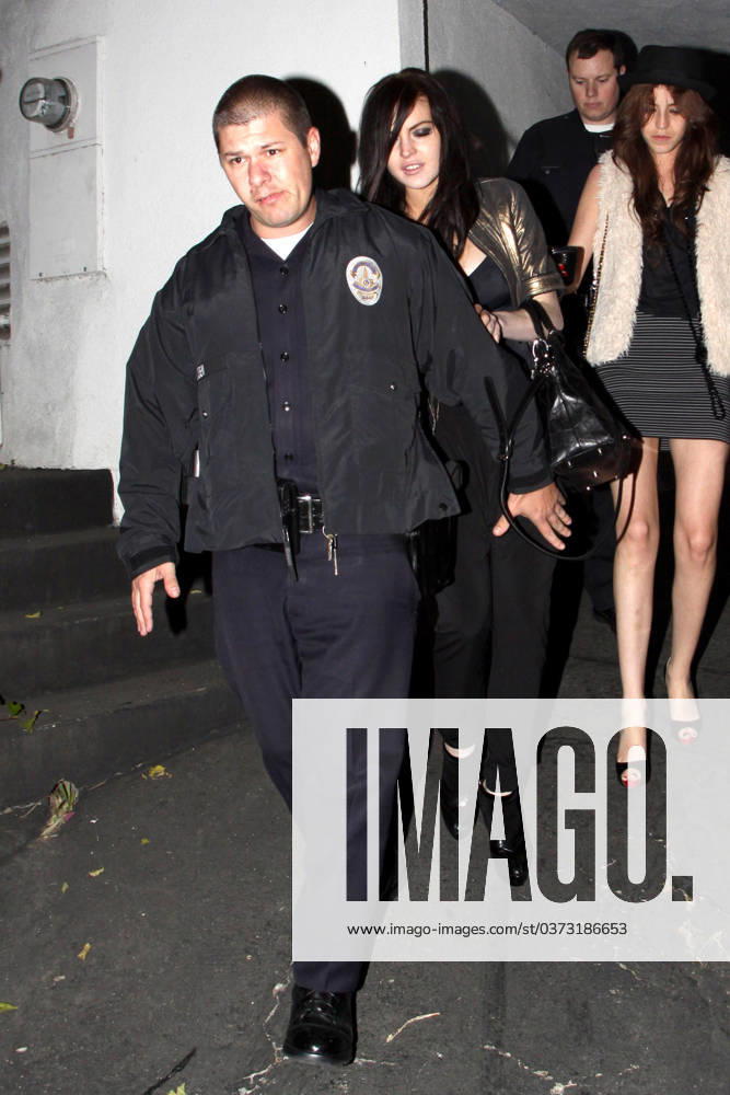 Lindsay Lohan gets a police escort to her vehicle as she leaves a house party at approx 05.30am 38894, WEST HOLLYWOOD, CALIFORNIA - Tuesday March 23 2010. Lindsay Lohan gets a police escort to her vehicle as she leaves a house party at approx 05.30am. The young actress managed to stay upright as she teetered out of the house on a pair of killer heels. She hadn t been so fortunate when she arrived, taking a tumble into an ornamental cactus bush!! (See PCN set 38889PCN_Lindsay). , Credit:David Tonnessen, PacificCoastNews.com Avalon USA, Los Angeles