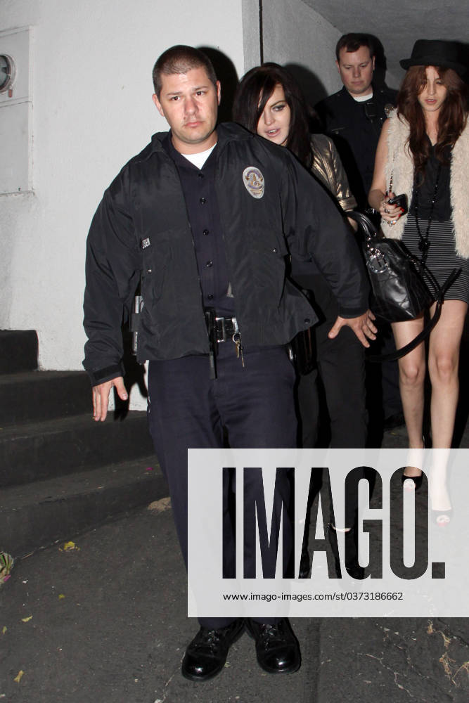 Lindsay Lohan gets a police escort to her vehicle as she leaves a house party at approx 05.30am 38894, WEST HOLLYWOOD, CALIFORNIA - Tuesday March 23 2010. Lindsay Lohan gets a police escort to her vehicle as she leaves a house party at approx 05.30am. The young actress managed to stay upright as she teetered out of the house on a pair of killer heels. She hadn t been so fortunate when she arrived, taking a tumble into an ornamental cactus bush!! (See PCN set 38889PCN_Lindsay). , Credit:David Tonnessen, PacificCoastNews.com Avalon USA, Los Angeles