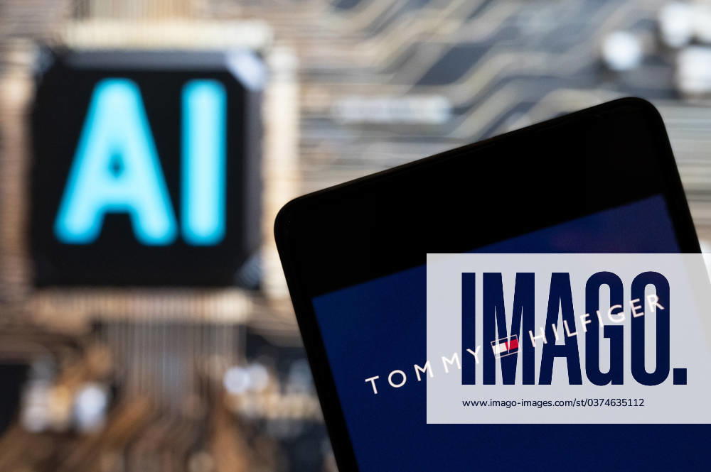 Logos displayed on smartphones in China - 10 Nov 2023 In this photo illustration, the American fashion brand Tommy Hilfiger logo seen displayed on a smartphone with an Artificial intelligence (AI) chip and symbol in the background. Hong Kong China