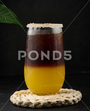 Iced coffee with orange juice in a transparent glass, refreshing bumble coffee on the table, black background layer coffee orange brown sweet cool ice espresso cold drink glass fresh juice beverage cocktail morning caffeine fruit syrup table yellow citrus juicy bumble slice nobody black