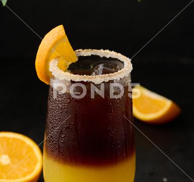 Iced coffee with orange juice in a transparent glass, refreshing bumble coffee on the table, black background coffee cold glass ice juice juicy layer morning nobody orange slice sweet syrup table yellow full beverage black brown bumble caffeine citrus cocktail cool drink espresso fresh fruit