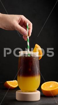 Iced coffee with orange juice in a transparent glass, refreshing bumble coffee on the table orange ocktail coffee cold cool drink espresso refreshment slice sweet syrup table yellow hold staw hand beverage black brown bumble caffeine citrus c fresh fruit glass ice juice juicy layer morning nobody