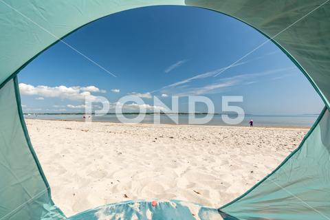 View from inside a tent onto beautiful white sand beach at the Baltic Sea at the Flensburger Förde in North Germany Beach sea ocean tent beach shelter camping Baltic Sea travel vacation holiday landscape coast campsite shore seashore POV outdoors camp adventure trip tourism backpacking active seascape peaceful calm quiet Germany Northern Germany coastline relax tranquil scenic beautiful view nature Holnis Flensburger Frde Foerde