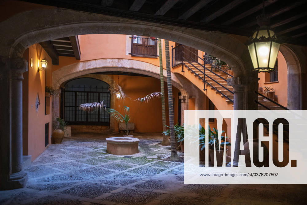 Spain Balearic islands Mallorca Palma de Mallorca Carrer de Can Savella stret Interior of some of the Majorcan patios Mallorca courtyard. Majorcan-style interior patios of some houses on Calle Can Savella. Can Vivot, declared an Asset of Cultural Interest and a Historic-Artistic Monument, has a spectacular stately courtyard populated by three vintage horse-drawn carriages. Behind this impressive entrance hides a no less surprising origin that dates back to the fourteenth century with the union of the raconada d en Berard and l alberg d en ClapÃ s, houses very close to each other. Prior to that, there is an Arab arch that, according to Montaner, is believed to be the roof of some baths. Mallorca Baleares Spain