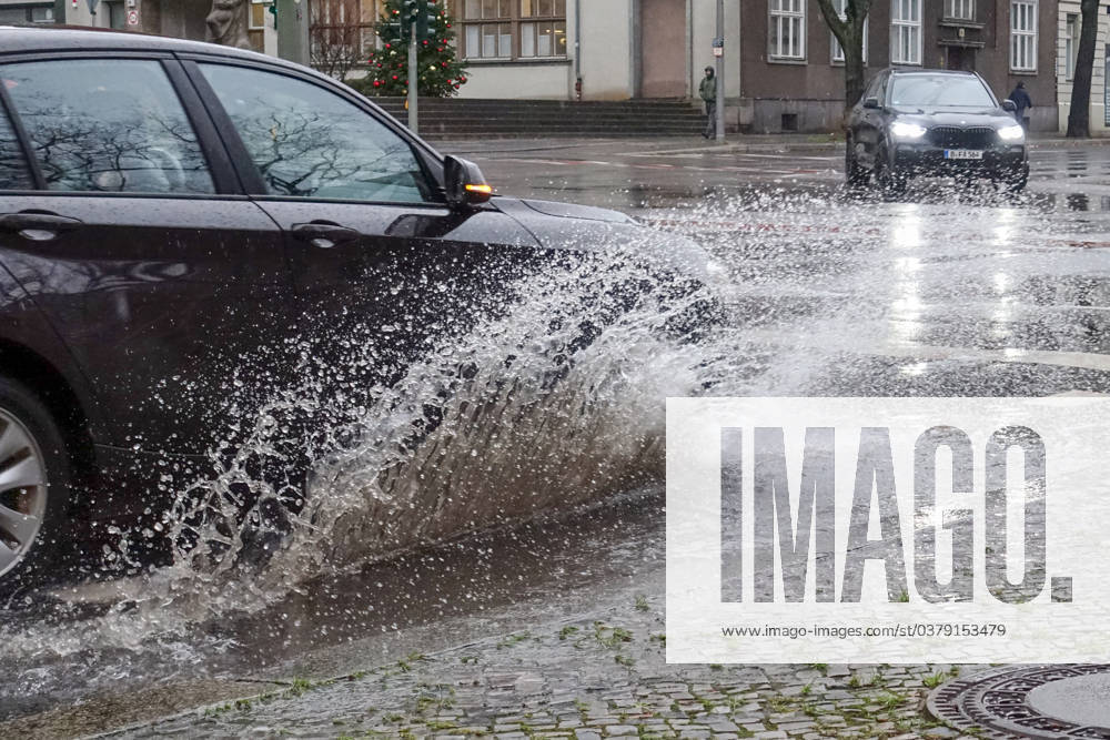 Berlin, GER car driving on a road through a big puddle everyday life, cropping, aquaplaning, exterior, exterior shot, auto