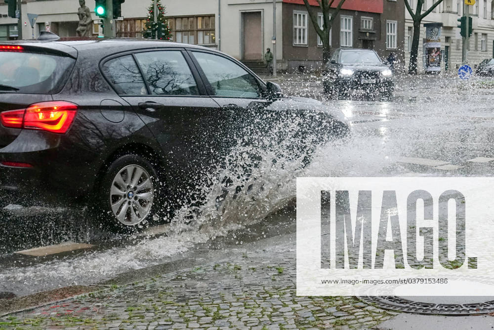 Berlin, GER car driving on a road through a big puddle everyday life, cropping, aquaplaning, exterior, exterior shot, auto