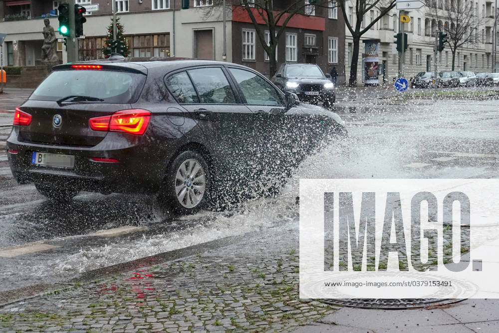 Berlin, GER car driving on a road through a big puddle everyday life, aquaplaning, exterior, exterior shot, automobiles, cars, car tr
